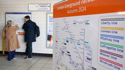 A new London Overground network map with people in the background looking at a tube map, in Highbury and Islington station on 15 February