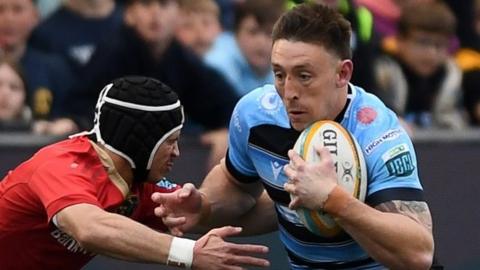 Josh Adams of Cardiff is challenged by Tom Farrell of Munster