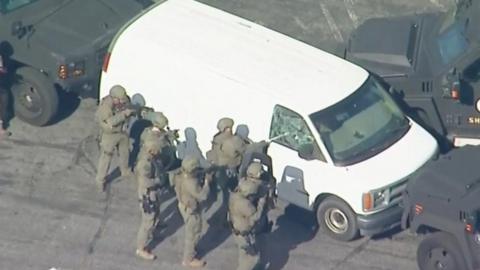 Armed police smash window of California shooting suspect's van