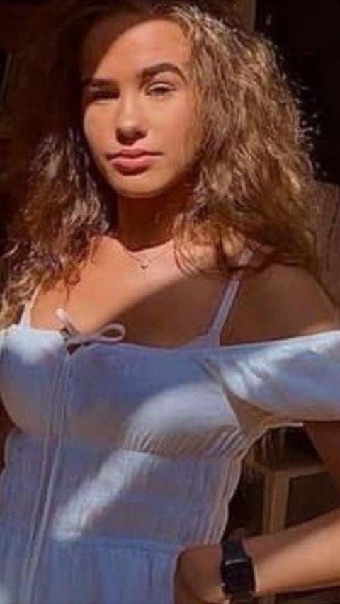 Young woman with long brown hair wearing a white summer dress