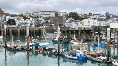 Guernsey fishing boats at Fish Quay St Peter Port on a cloudy day.