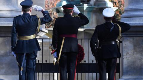 Members of the armed forces salute at the National War Memorial in Cardiff