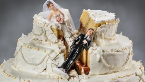 wedding cake with fallen figurines