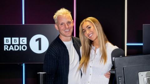 Jamie Laing and Sophie Habboo smiling together in the Radio 1 studio