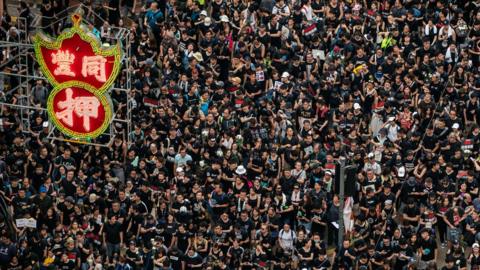 Protesters hold banners and shout slogans as they march on a street on June 16, 2019 in Hong Kong