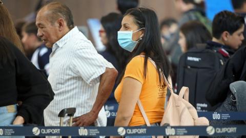 A passenger wears a protective mask at Mariscal Sucre International Airport, regarding the spread of the COVID-19 virus worldwide, in Quito, on March 1, 2020.