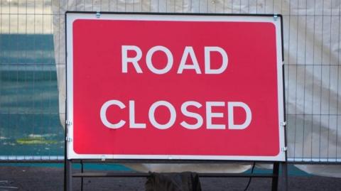 A red rectangular road closed sign