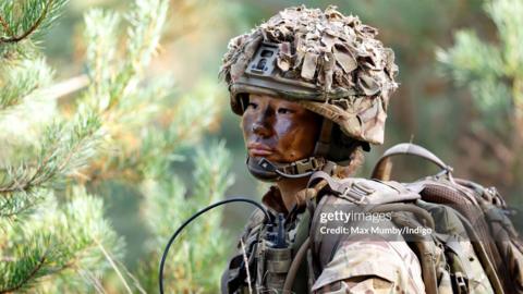 A female soldier of 1st Battalion London Guards takes part in a training exercise on Hankley Common