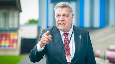 Football manager looking concerned on a pitch