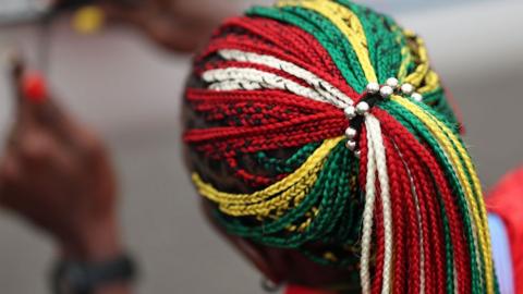 Togolese rower Akoko Komlanvi wears matching braids and nails in green s she builds her boat ahead of a rowing event at Vaires-Sur-Marne Nautical Stadium - 24 July 2024 in Paris, France