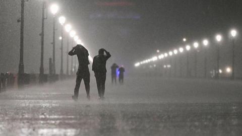People seen covering their heads during heavy rainfall and a storm at Kartavyapath on May 21, 2025 in New Delhi, India.