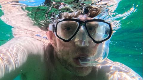 A man snorkelling under water