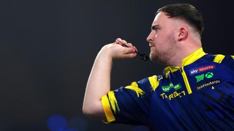 Luke Littler throws a dart