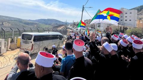 Druze people in Majdal Shams welcome buses carrying a Druze delegation from Syria