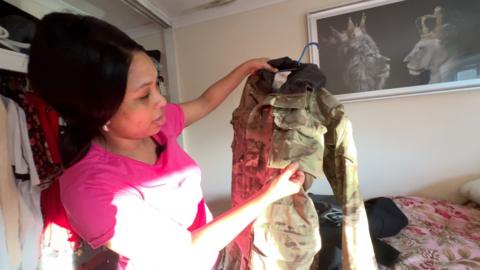 Anne-Marie Rismay examines husband Richard's combats which have been affected by mould in their army owned home in Aldershot.