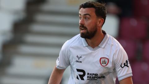 Eoghan O'Connell in action for Barnsley wearing a white away jersey