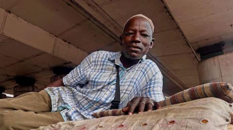  Liya’u Sa’adu lying on his mattress under a bridge in Lagos, Nigeria