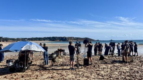 camera crew on beach set filming 