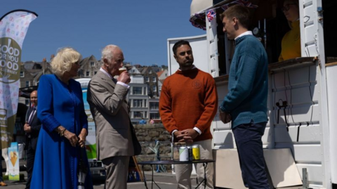 The King and Queen meet the owners of a local brewery - with the King sipping a small beer.