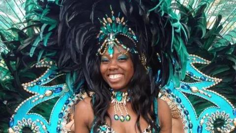 A woman wearing an extravagant blue and green peacock costume at St Pauls Carnival.