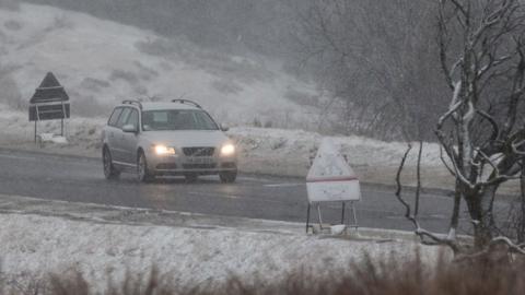 Vehicles drive along the road at the base of Pont ar Daf in the Brecon Beacons