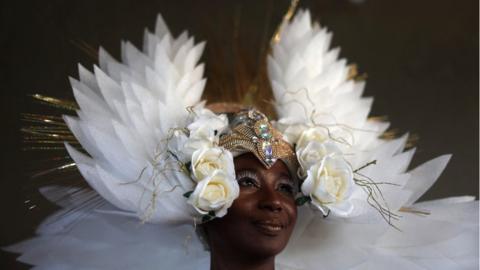 Viviane Oliveira wears a white costume as she represents an angel, before a Christmas celebration in the Caju slums complex in Rio de Janeiro, Brazil, December 14, 2023.