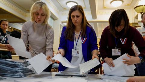 Three members of an electoral commission counting votes in Moscow