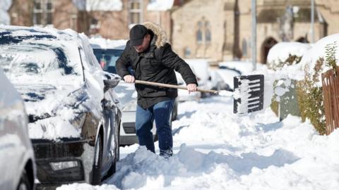 Man digs out car from snow