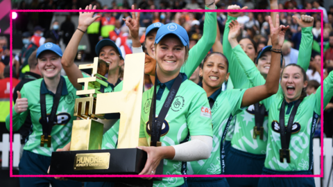 Oval Invincibles captain Dane van Niekerk holds up The Hundred trophy as her players celebrate behind