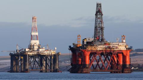 An oil platform standing amongst other rigs that have been left in the Cromarty Firth near Invergordon in the Highlands of Scotland