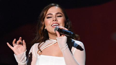 Macey Landon-Jones singing on stage while holding a microphone