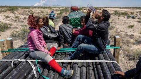 Immigrants ride atop a freight train while en route to the U.S.-Mexico border on May 10, 2023 near Ciudad Juarez, Mexico.