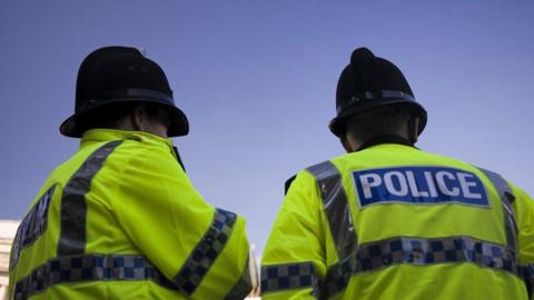 Two police officers facing away from the camera