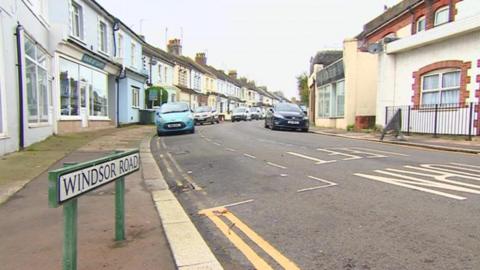 The corner of a residential street with a sign reading 'Windsor Road'