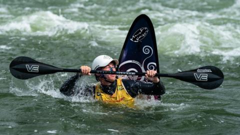 Sam Wilson a Squirt Kayaker completing a trick in the water in Germany.