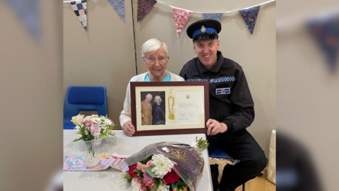 Woman shows a telegram that she received from the King for her 100th birthday