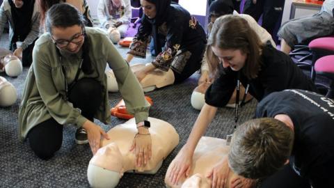 students practice first aid on dummies