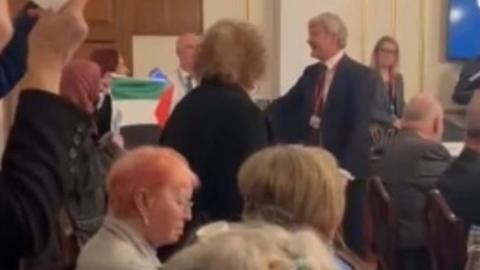 Craige Southern in the town hall can be seen near the top right of the picture, in a red tie, with Jenny Hurley opposite him, just visible behind a Palestinian flag