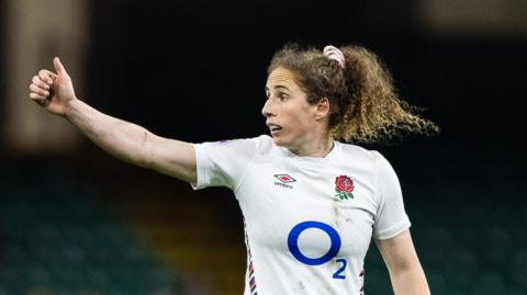 Abby Dow giving a thumbs-up while playing for England against Wales in the Women's Six Nations