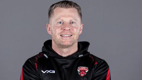 Mike Grady, coach of Salford, smiling towards the camera