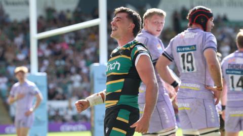 George Furbank, wearing his green, black and yellow striped Northampton Saints kit, celebrates his try against Gloucester in May 
