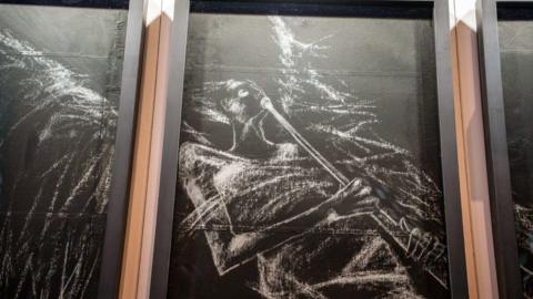 Three framed sketches of one of Coventry Cathedral's angels. They are chalk on black paper and have been framed. 