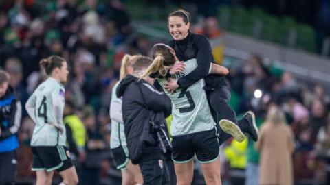 Rhian Wilkinson celebrates Wales' qualification for Euro 2025 with defender Gemma Evans