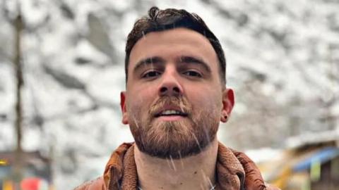 Image of Erfan Soltani, he has a beard and short brown hair. 