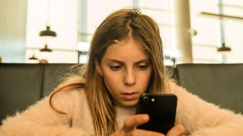 A girl looks at her mobile phone