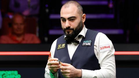 Hossein Vafaei chalking his cue