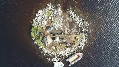 An artificial island built from large white stones in a Scottish loch - captured from above