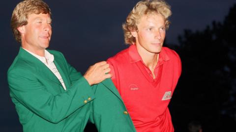 Ben Crenshaw helps Bernhard Langer on with his Green Jacket after winning in 1985