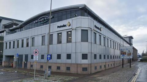Petrofac building in Aberdeen. It is a large white building on the corner of the street.