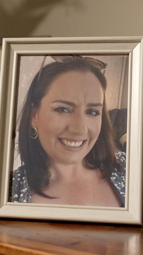 A photo frame with a picture of a woman with brown hair smiling at the camera